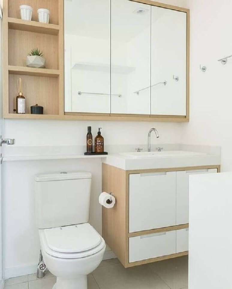 9. Banheiro pequeno decorado com espelheira e gabinete branco com detalhe em madeira &ndash; Foto: Arkpad