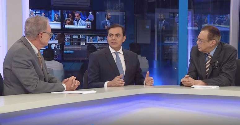 Marcos Tolentino sendo entrevistado pelos âncoras Hermano Henning e Nei Gonçalves Dias na Rede Brasil
