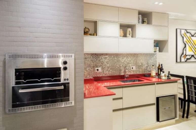 65. Área gourmet com churrasqueira pequena e cozinha com bancada vermelha moderna Foto Andrea Petini