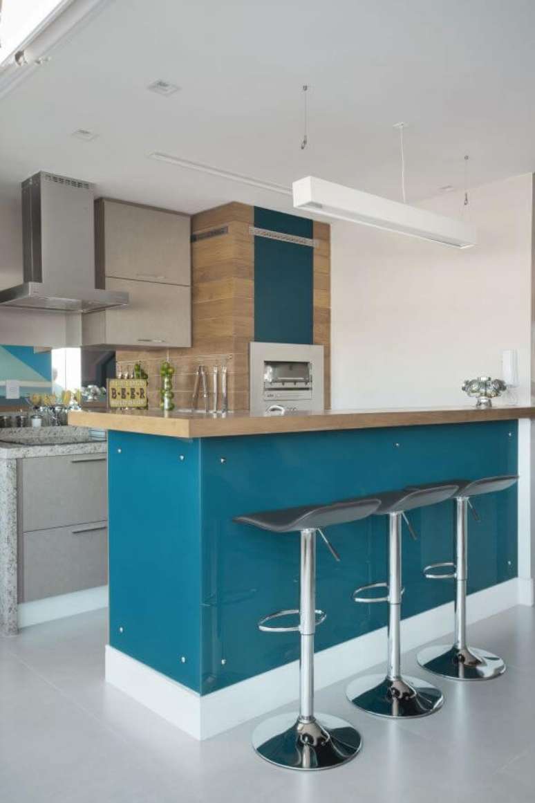 32. Cozinha com churrasqueira pequena revestida de madeira e tinta azul – Foto Mariana Martini