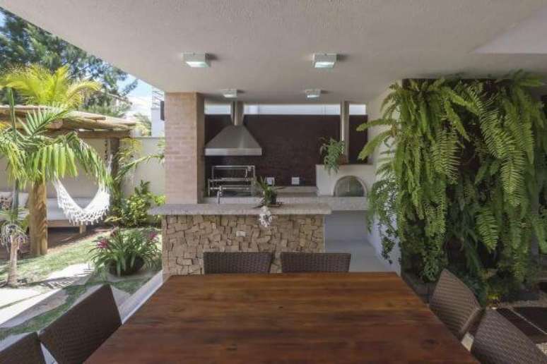 69. Área de lazer com churrasqueira pequena e decoração com plantas de jardim vertical – Foto Jannini Sagarra Arquitetura