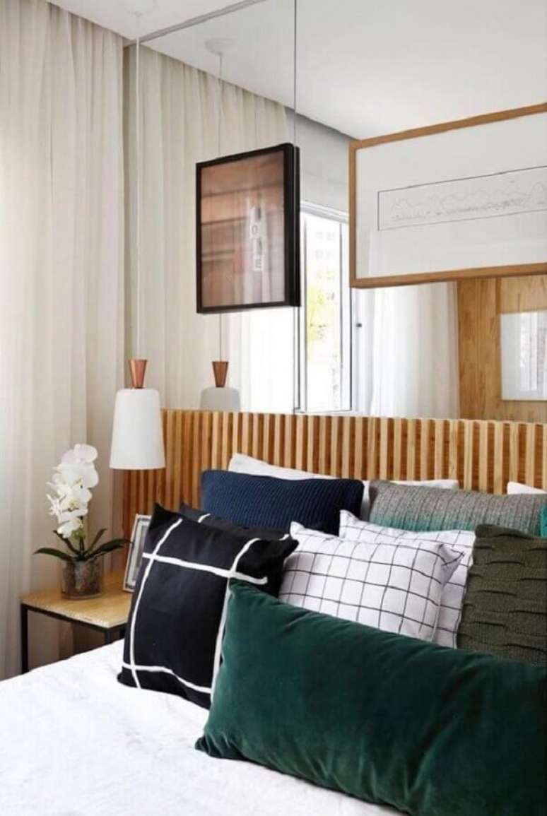 12. Almofadas para cama de quarto de casal decorado com parede espelhada e cabeceira de cama box ripada – Foto: Duda Senna