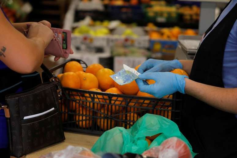Pessoa paga por suas compras em loja de frutas de Ronda, na Espanha, em meio a disseminação da Covid-19
09/10/2020
REUTERS/Jon Nazca