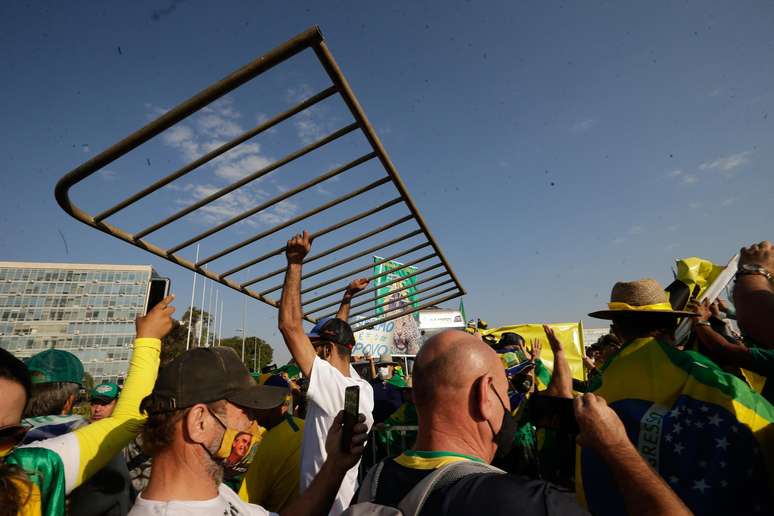 Apoiadores do presidente Jair Bolsonaro (sem partido) derrubam cercas de proteção com o intuito de invadir a área próxima aos prédios do Congresso Nacional e STF