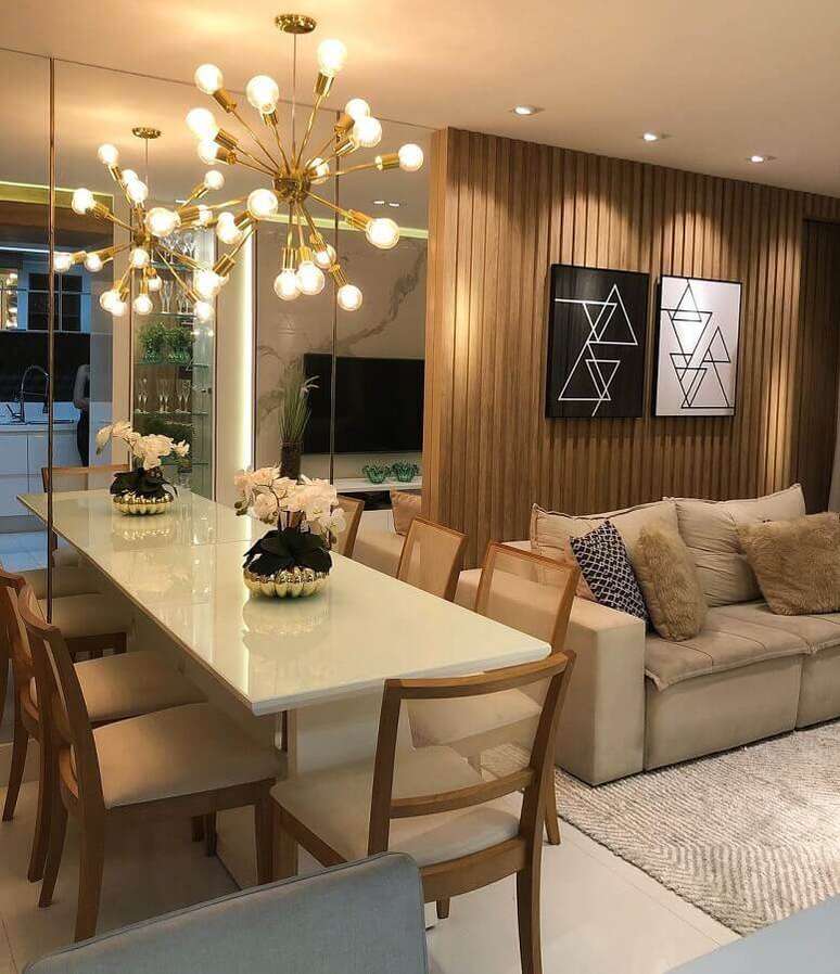 40. Lustre moderno para sala de estar e jantar integrada decorada com painel ripado de madeira – Foto: De Paula e Nobrega