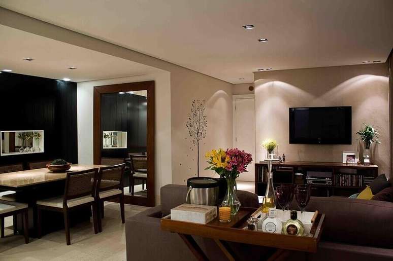 50. Sala de estar e jantar integrada decoradas com espelho de parede grande e aparador barzinho &ndash; Foto: Karen Pisacane