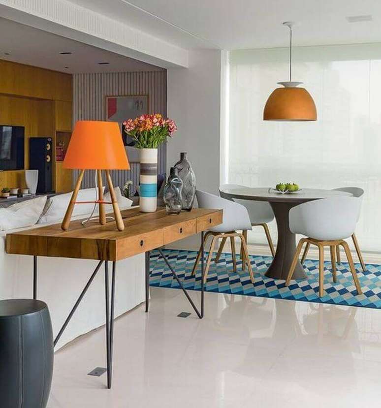 18. Decora&ccedil;&atilde;o de sala de estar e jantar integrada com aparador de madeira e lumin&aacute;ria redonda &ndash; Foto: Casa Pensada