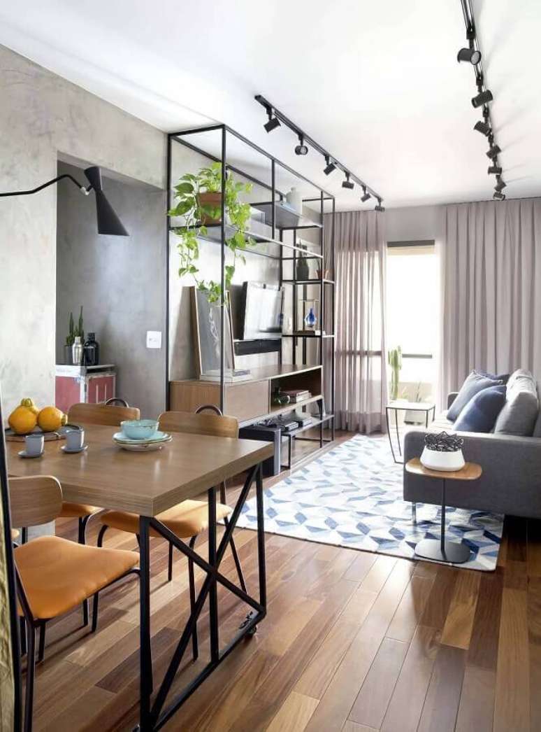 38. Decoração estilo industrial com trilho de luz para sala de estar e jantar integrada – Foto: Mandril Arquitetura + Interiores