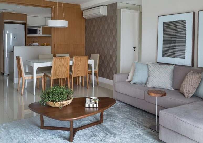 21. Decora&ccedil;&atilde;o de sala de estar e jantar integrada com sof&aacute; cinza e mesa de centro diferente &ndash; Foto: Ana Yoshida