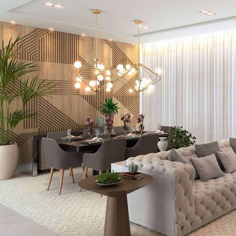53. Sala de estar e jantar integradas modernas decoradas com sofá cinza capitonê e parede 3D de madeira – Foto: Katia Lopes