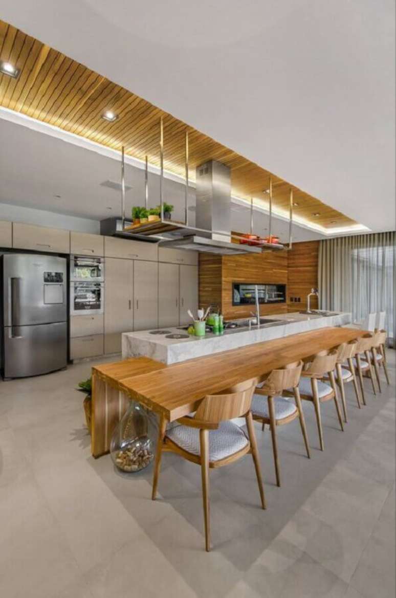 7. Decoração de cozinha planejada grande com ilha de mármore e bancada de madeira – Foto: Studio Colnaghi