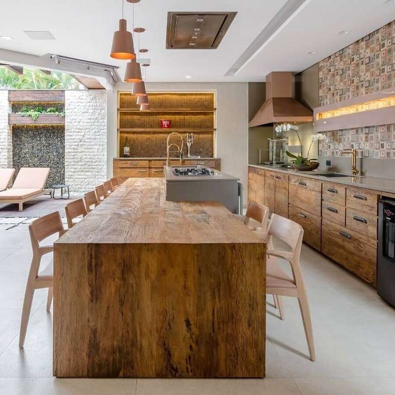 59. Mesa de madeira rustica para decoração de cozinha com ilha planejada – Foto: Okha Arquitetura