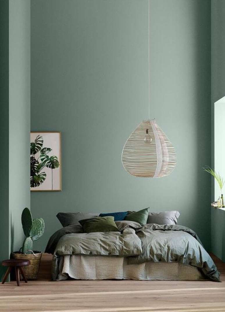 28. Quarto com parede verde sage e roupa de cama combinando – Foto Revista Arquitectura y Diseno