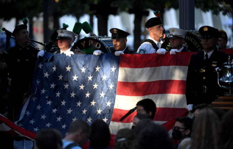 Policiais e bombeiros seguram bandeira dos EUA em cerimônia pelos 20 anos dos atentados de 11 de setembro, em Nova York