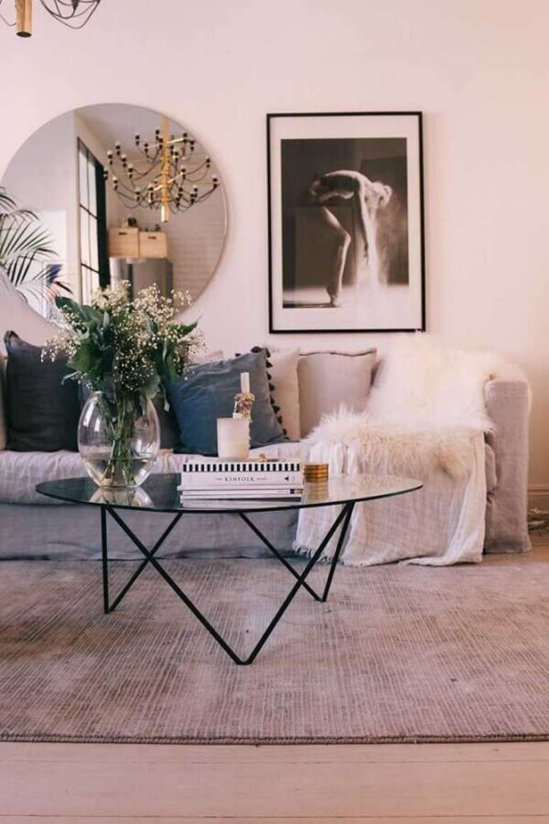1. Espelho redondo na sala de estar decorada com sofá cinza e mesa de centro de vidro – Foto: Decor Fácil