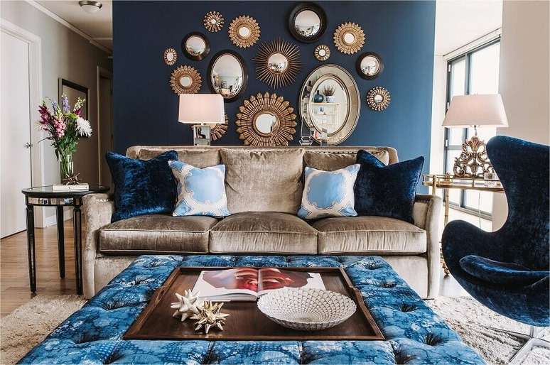 7. Parede com espelho na sala de estar azul decorada com sofá marrom – Foto: Design Homes