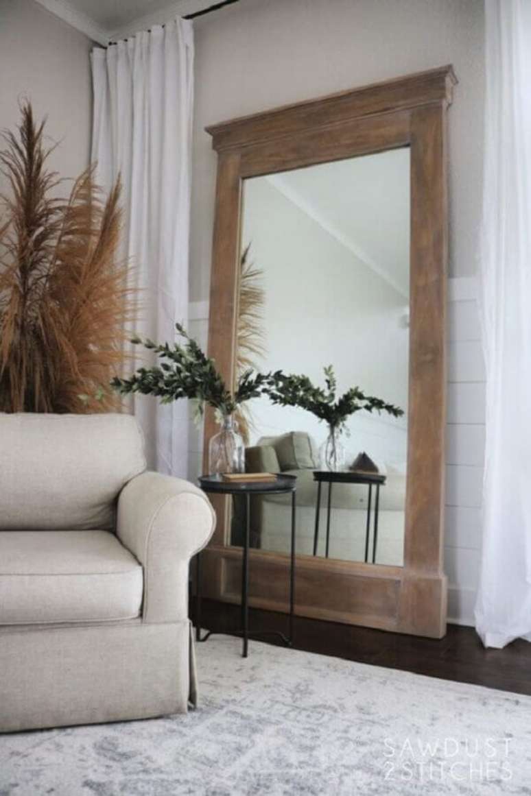 32. Espelho grande na sala de estar decorada com poltrona bege e mesa lateral redonda – Foto: Sawdust 2 Stitches