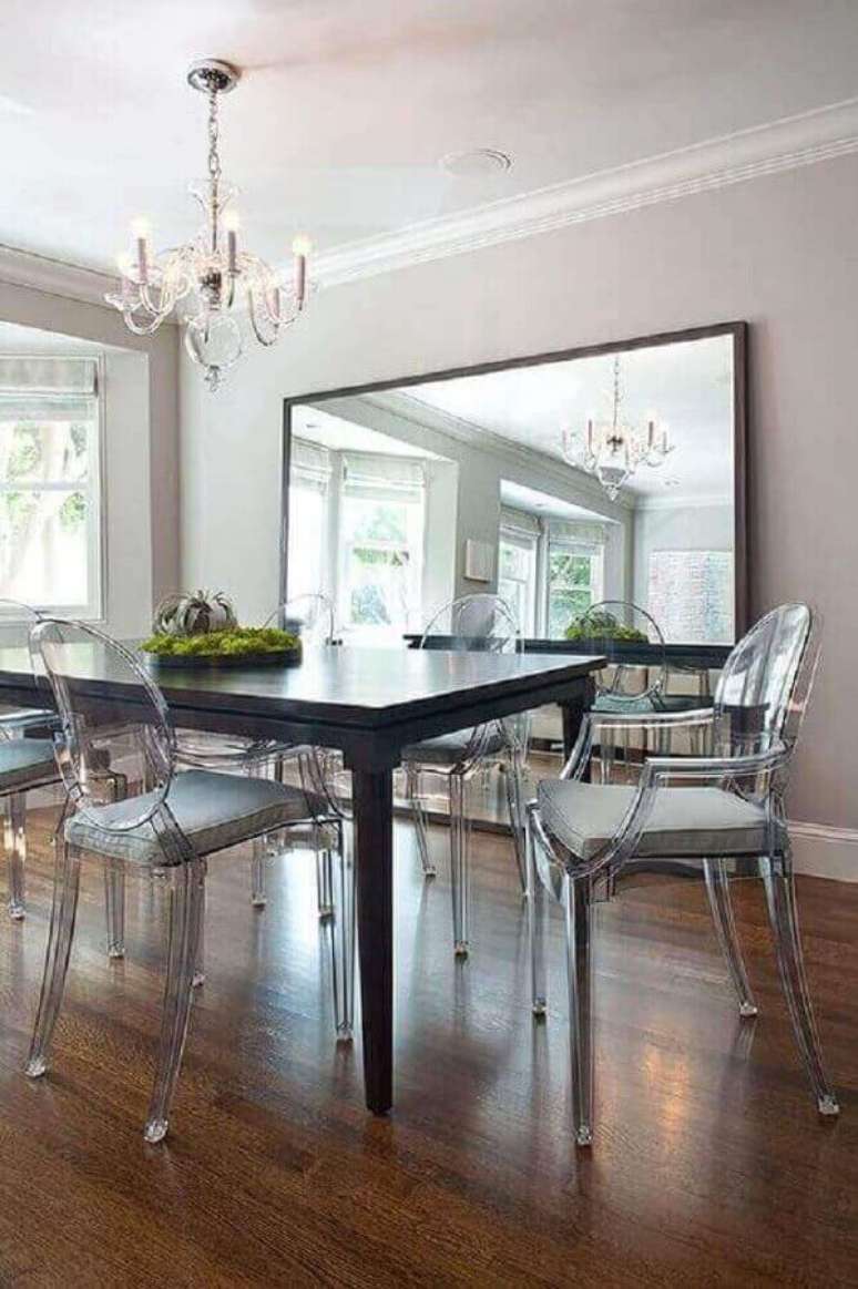 15. Decoração com cadeira transparente e espelho na sala de jantar – Foto: Anthropologie