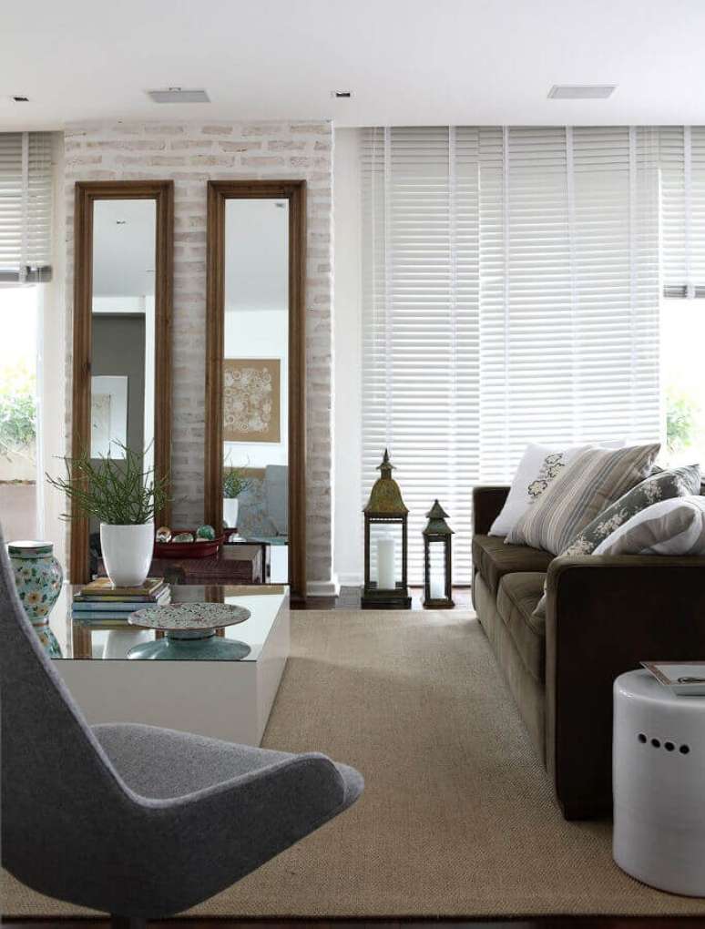 39. Espelho na sala de estar grande decorada com sof&aacute; marrom e parede tijolinho &ndash; Foto: Caroline Gabriades