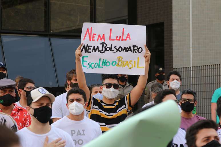 Manifestante leva cartaz contra Lula e Bolsonaro em ato em Goiânia