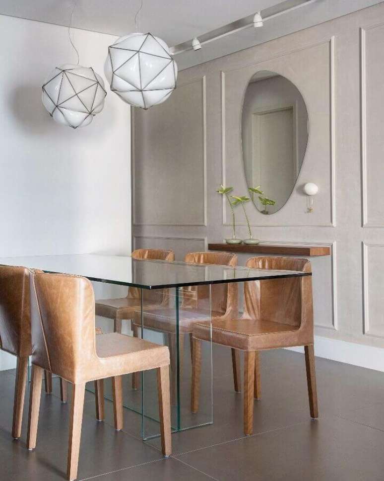 54. Modelo diferente de espelho na sala de jantar decorada com mesa de vidro e cadeiras de couro – Foto: FPR Studio