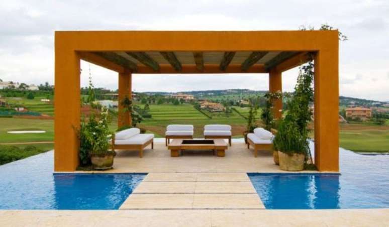 33. Piscina com pergolado de madeira coberto e conjunto de sofá chaise branco – Foto Ana Maria Vieira Santos