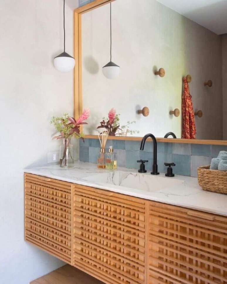 7. Gabinete de madeira com bancada de mármore para decoração de banheiro simples e bonito – Foto: Migs Arquitetura