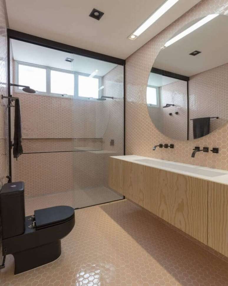 60. Revestimento hexagonal rosa para decoração de banheiro bonito com gabinete suspenso de madeira – Foto: WF Arquitetos