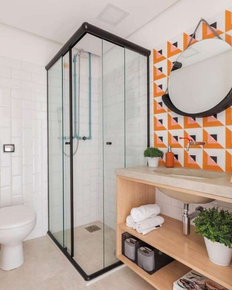 14. Banheiro simples e bonito decorado com revestimento colorido e espelho redondo – Foto: SP Estúdio