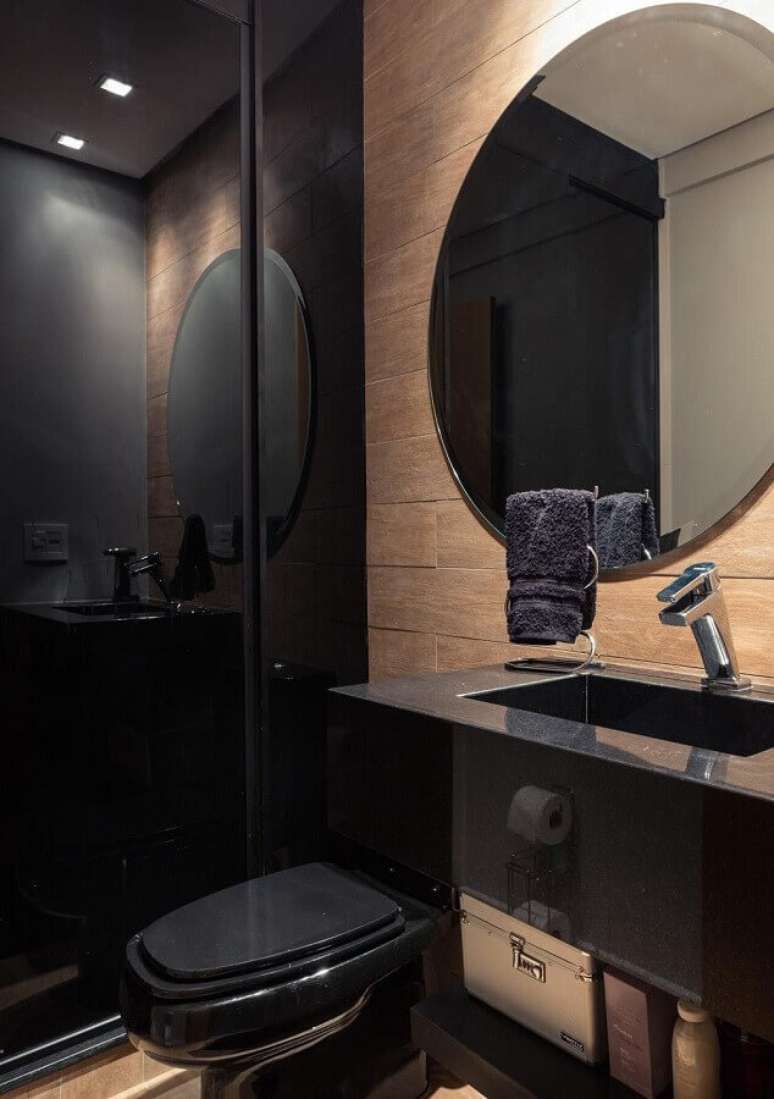 36. Espelho redondo para banheiro bonito preto decorado com revestimento de madeira – Foto: Braccini + Lima Arquitetura