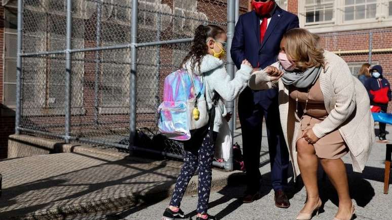 Professora cumprimenta aluna em escola de Nova York, em foto de abril; cidade reabriu suas salas de aula neste 13 de setembro