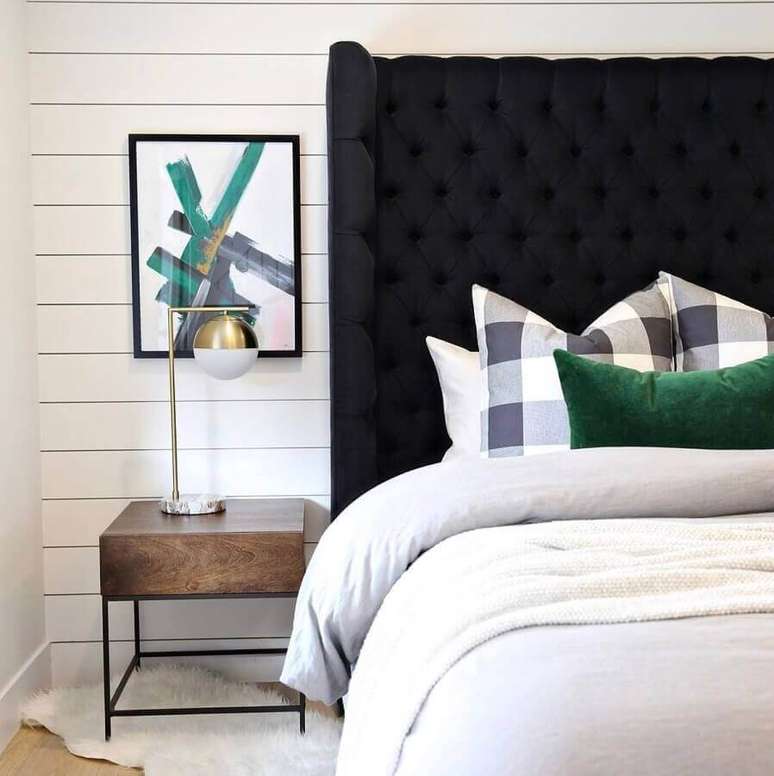 9. Cabeceira almofadada capitonê preta para decoração de quarto branco com criado mudo pequeno – Foto: Graham Hill Design