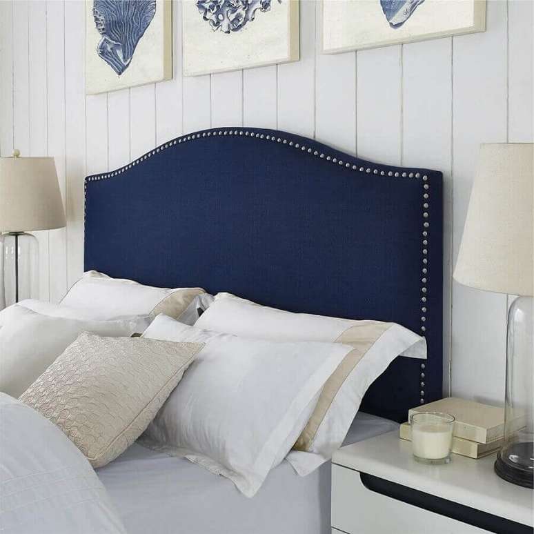 34. Decoração de quarto branco com cabeceira almofadada azul marinho com tachas – Foto: Gameol