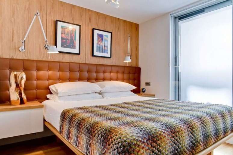 47. Parede de madeira para quarto decorado com cabeceira almofadada de couro – Foto: HomeDSGN