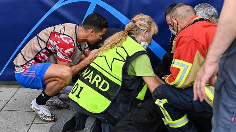 Cristiano Ronaldo socorrendo a brasileira atingida por uma bolada (Foto: Fabrice COFFRINI / AFP)