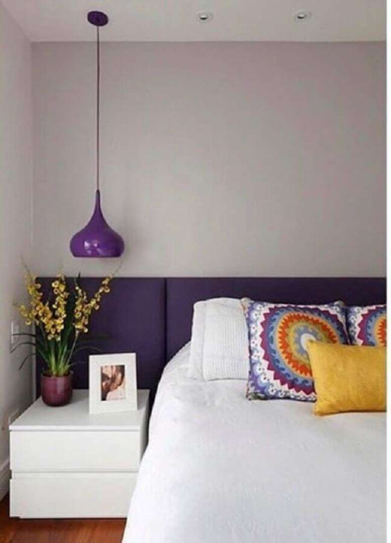27. Cama com cabeceira almofadada para decoração de quarto de casal com luminária roxa – Foto: Deu Decor
