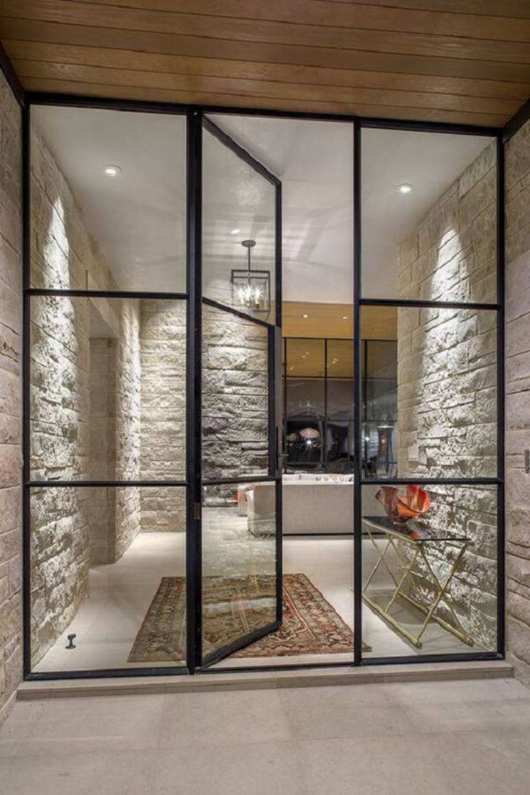 1. As portas de ferro com vidro para sala combinam perfeitamente com paredes de pedra. Fonte: Krausch Architectural Windows & Doors