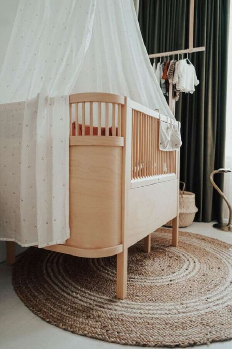 14. Berço de bebê de madeira para decoração de quarto com tapete redondo rustico – Foto: fonQ
