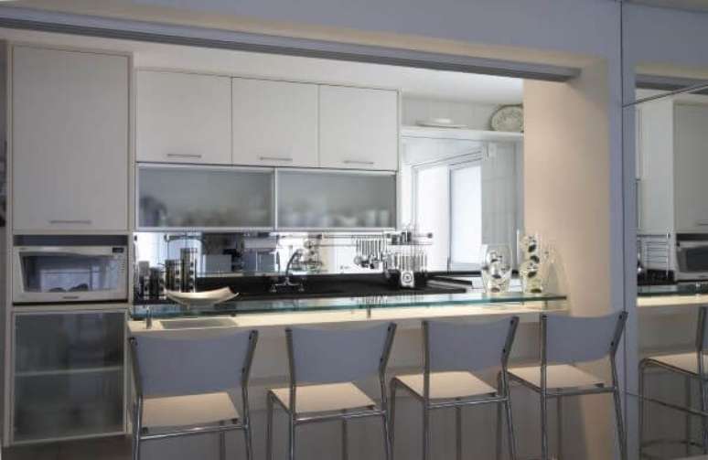 38. Cozinha com arm&aacute;rio de vidro para copos e pratos organizados &ndash; Foto Leoshehtman