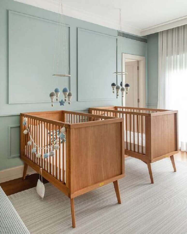 16. Berço de bebê de madeira para quarto de gêmeos decorado com parede azul claro – Foto: Triplex Arquitetura