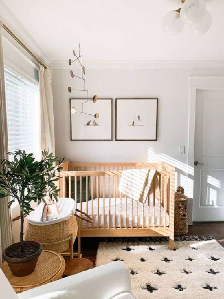 54. Quarto de bebê branco decorado com vaso de planta e berço de madeira simples – Foto: Elizabeth Street Post