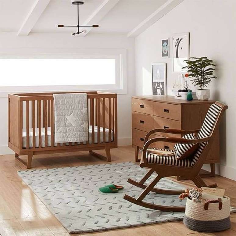 57. Quarto de bebê simples decorado com cadeira de balanço e berço de madeira – Foto: Crate and Barrel