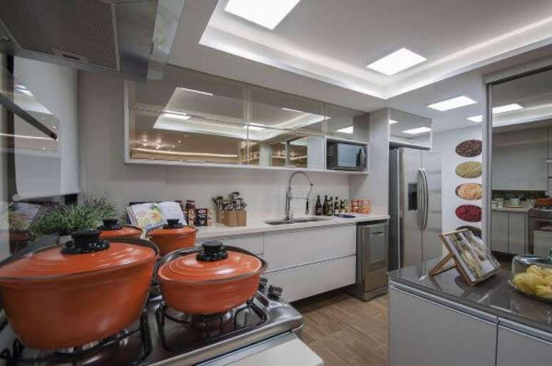 31. Cozinha branca com arm&aacute;rio a&eacute;reo de vidro reflecta &ndash; Foto Marel