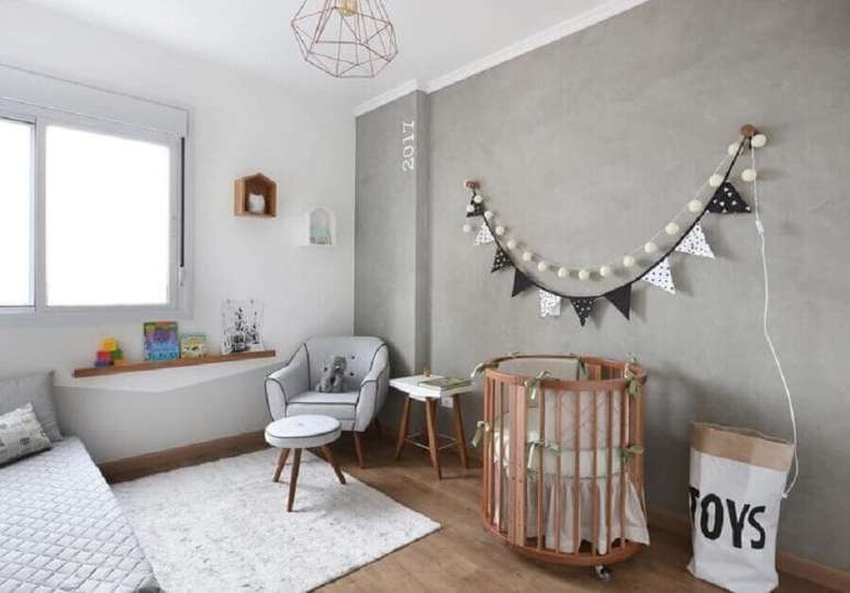 51. Mini berço de madeira para quarto de bebê cinza e branco decorado com parede de cimento queimado – Foto: Studio Vida Design