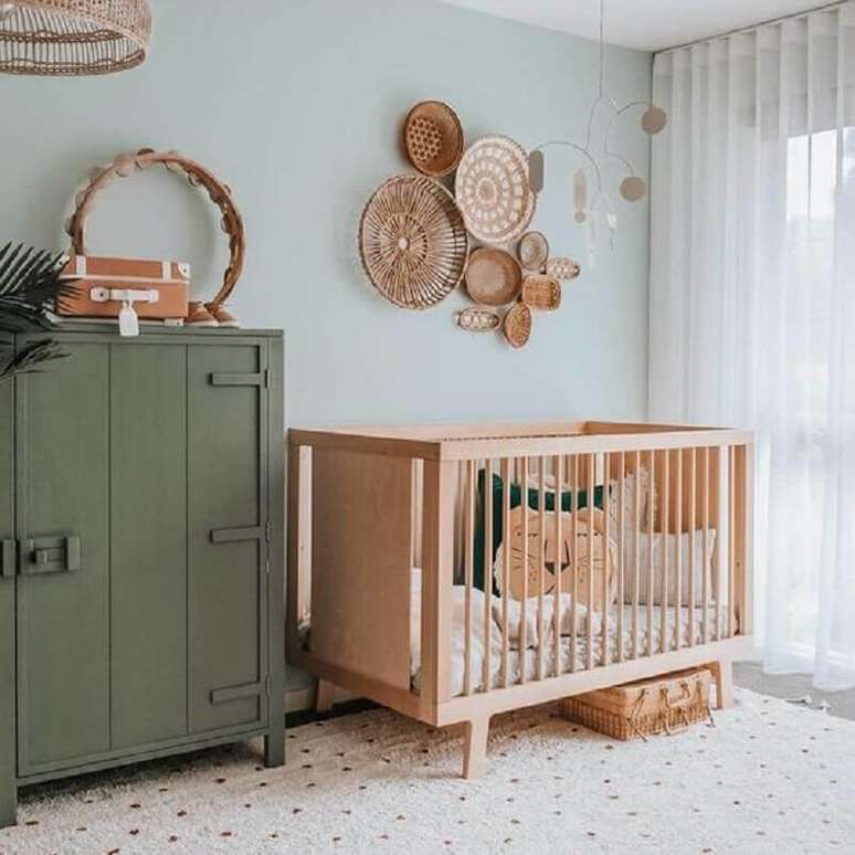 17. Berço de bebê de madeira para quarto simples decorado com parede azul claro e armário antigo – Foto: DecoIdeas