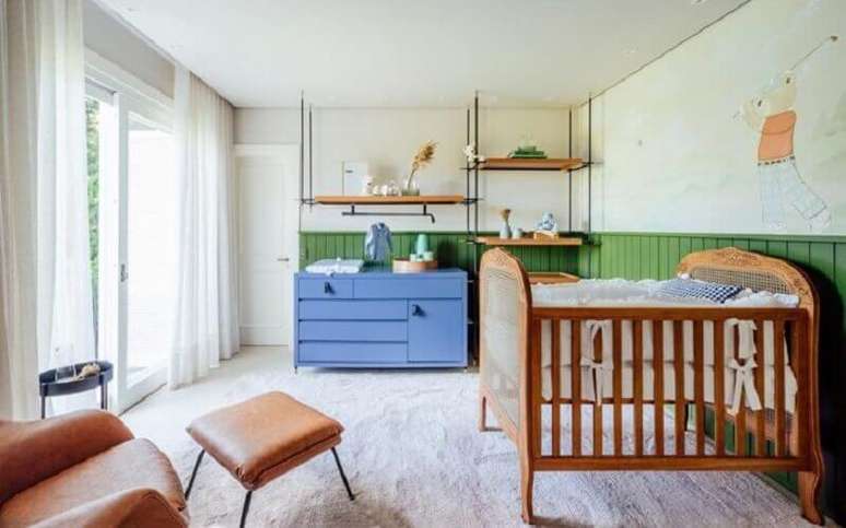 30. Berço de madeira simples para quarto de bebê decorado com cômoda azul e meia parede verde – Foto: Greisse Panazzolo