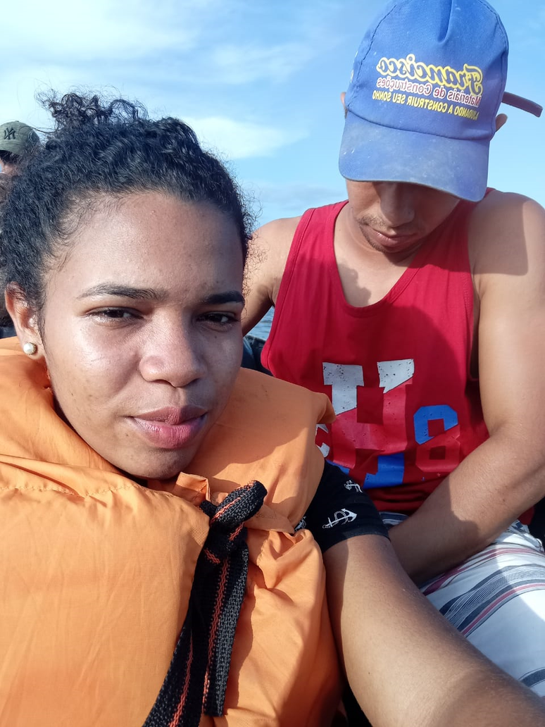Karine e Carlos (ao fundo) em foto tirada na embarcação, horas antes do naufrágio: família de casal pede apoio nas buscas após acidente
