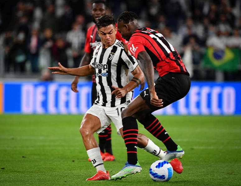 Os atacantes Dybala, da Juventus, e Rafael Leão, do Milan, disputam uma bola (Foto: Isabella BONOTTO / AFP)