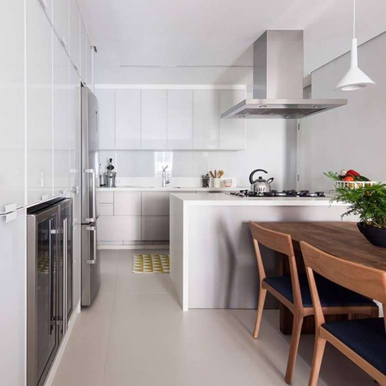 52. Mesa de madeira para decoração clean de sala e cozinha americana branca – Foto: Iná Arquitetura