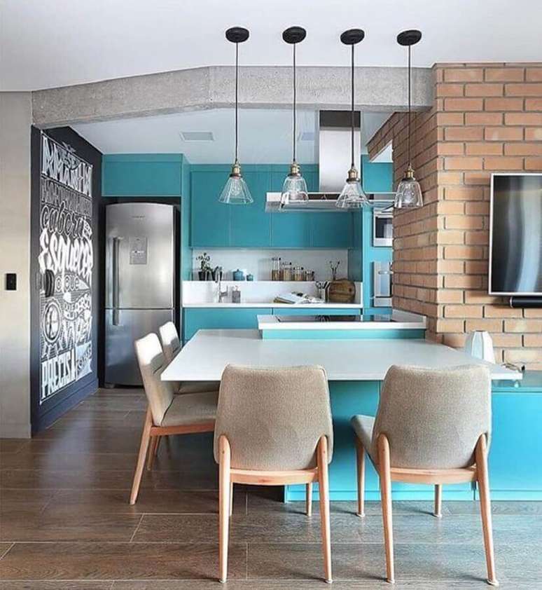 5. Azul turquesa para decoração de sala e cozinha americana com parede de tijolinho – Foto: Quattrino Arquitetura